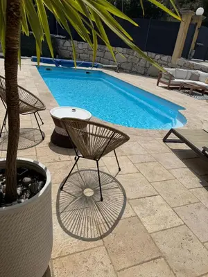 a swimming pool with a chair and a table at Charmant appartement, piscine 15 min de Nice in Carros
