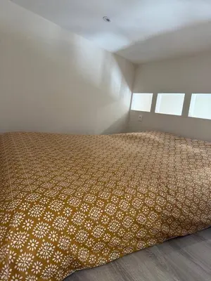 a bedroom with a bed in a room with windows at Charmant appartement, piscine 15 min de Nice in Carros