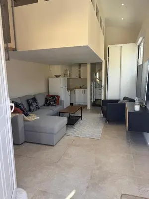a living room with a couch and a table at Charmant appartement, piscine 15 min de Nice in Carros