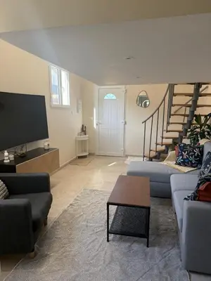 a living room with two couches and a tv at Charmant appartement, piscine 15 min de Nice in Carros