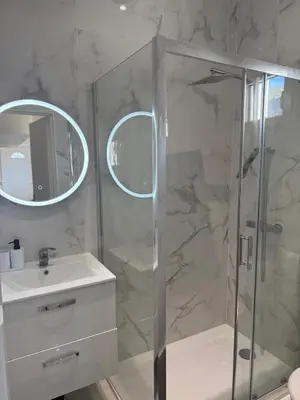 a bathroom with a shower and a sink and a mirror at Charmant appartement, piscine 15 min de Nice in Carros