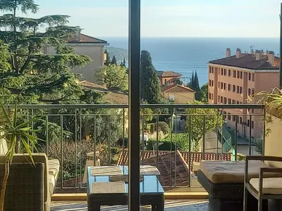 a room with a balcony with a view of the ocean at Apartement ensoleillé vue mer in Villefranche-sur-Mer
