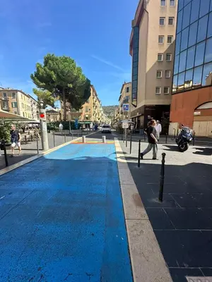 a person is walking on a city street with a fountain at Studio Rue Bonaparte in Nice