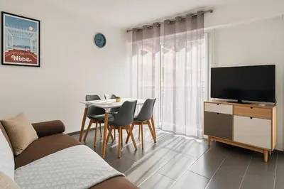 a living room with a couch and a table with chairs at Appartement confortable avec balcon - Proche Gare Riquier SNCF in Nice