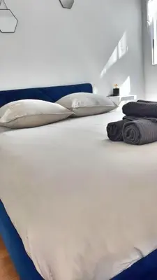 a bed with white sheets and pillows on it at Appartement confortable avec balcon - Proche Gare Riquier SNCF in Nice