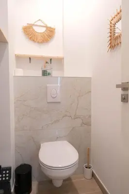 a bathroom with a white toilet and a stone wall at Nice Port studio avec grande baignoire in Nice