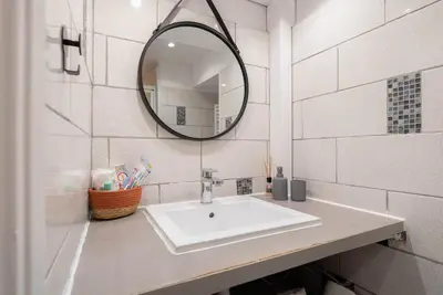 a white bathroom with a sink and a mirror at Studio 4 couchages in Nice