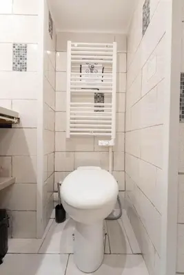 a white bathroom with a toilet and a window at Studio 4 couchages in Nice