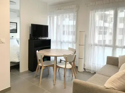 a living room with a table and chairs and a couch at Modern Studio by Port & Old Town in Nice