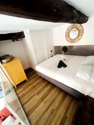 a small bedroom with a bed and a mirror at Duplex Place Massena in Nice