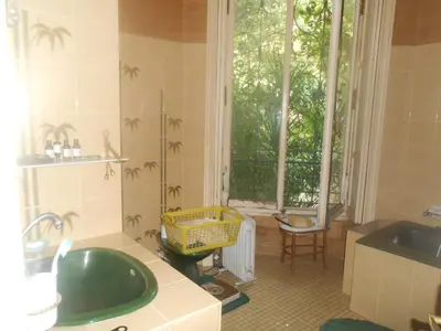 a bathroom with a green sink and a window at Une chambre chez l'habitant a Nice - Cimiez in Nice