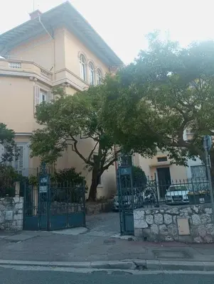 a house with a gate and a tree in front of it at Une chambre chez l'habitant a Nice - Cimiez in Nice