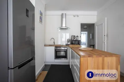 a kitchen with white cabinets and a wooden counter top at Apartment neighborhood Liberation in Nice