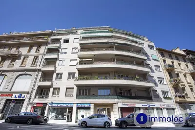 a large white building with cars parked in front of it at Apartment neighborhood Liberation in Nice