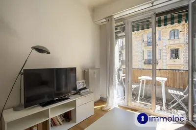 a living room with a tv and a large window at Apartment neighborhood Liberation in Nice