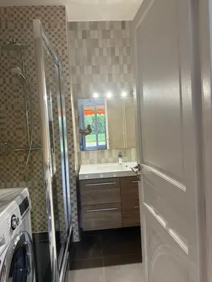 a bathroom with a sink and a mirror and a door at Beautiful 3 bedroom apartment with nice garden in Nice