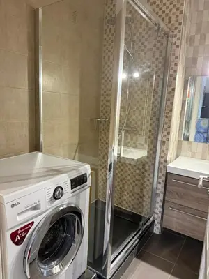 a washing machine in a bathroom with a shower at Beautiful 3 bedroom apartment with nice garden in Nice