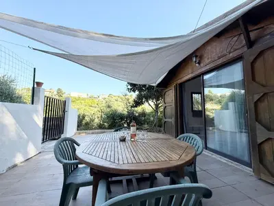 a wooden table and chairs on a patio at Charmant chalet avec jardin in Nice