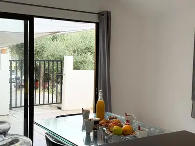 a table with a bowl of fruit and a bottle of wine at Charmant chalet avec jardin in Nice