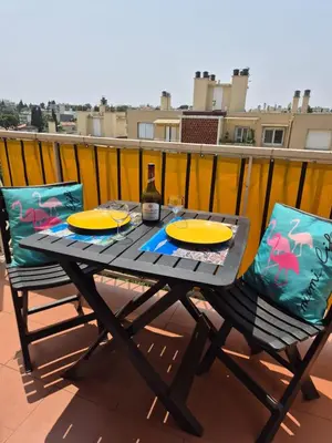 a patio table with two chairs and a bottle of wine at F2 vue mer et montagne au calme in Nice