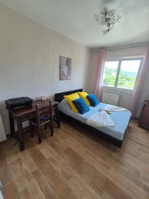 a bedroom with a bed and a desk and a window at F2 vue mer et montagne au calme in Nice
