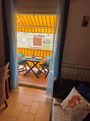 a room with a patio with a table and chairs at F2 vue mer et montagne au calme in Nice