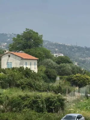 a car parked in front of a house on a hill at F2 vue mer et montagne au calme in Nice