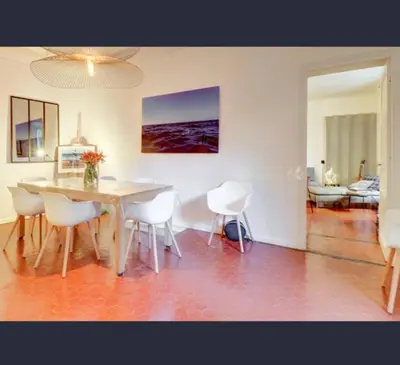 a dining room with a table and white chairs at Exceptional Location Beaches Cours SALEYA in Nice