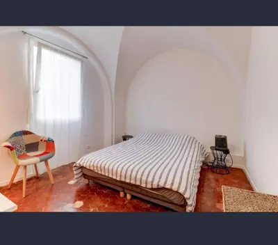 a bedroom with a bed and a chair and a window at Exceptional Location Beaches Cours SALEYA in Nice