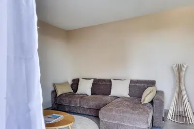 a living room with a couch and a table at Les Vagues du 5e 4 personnes , 2 chambres , clim , wifi , Cap3000 à pied , parking in Saint-Laurent-du-Var