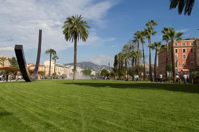 a park with green grass and palm trees and buildings at Nice Renting - PAGANINI - New Lovely Cosy Flat in Heart of Nice in Nice