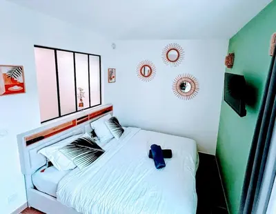 a bedroom with a white bed with a blue shirt on it at Studio avec balnéo proche plage in Nice