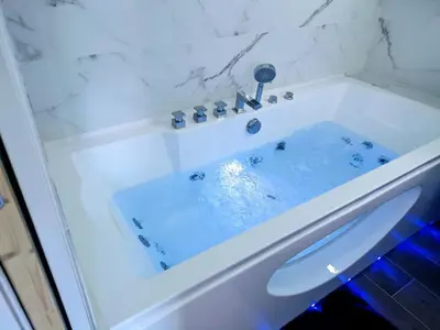 a white bath tub with a sink in a bathroom at Studio avec balnéo proche plage in Nice
