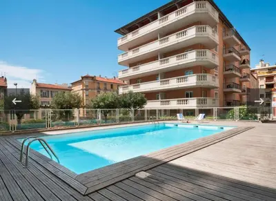 a swimming pool in front of a building at Studio avec balnéo proche plage in Nice