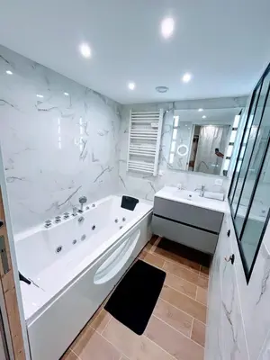 a white bathroom with a tub and a sink at Studio avec balnéo proche plage in Nice