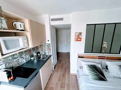 a small apartment with a kitchen and a couch at Studio avec balnéo proche plage in Nice
