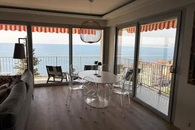 a living room with a table and views of the ocean at Superb apartment with exceptional sea view in Nice