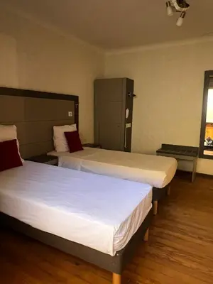two beds in a hotel room with two beds at T2 Pasteur in Nice