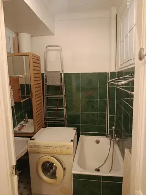 a small bathroom with a washing machine in it at Chambre niçoise in Nice