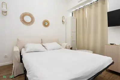 a living room with a table and a couch at WeHost D1 - Sea, Sauna & Sun - Studio 2pers in Nice