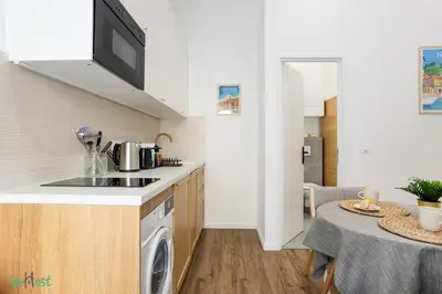 a small kitchen with a table with a table cloth at WeHost D1 - Sea, Sauna & Sun - Studio 2pers in Nice