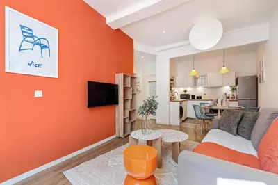 a living room with an orange accent wall at Nice Renting - COLLET - Cocoon Design Old Nice Beach Massena Saleya in Nice