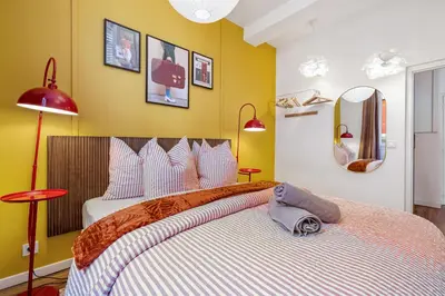 a bedroom with a large bed with yellow walls at Nice Renting - COLLET - Cocoon Design Old Nice Beach Massena Saleya in Nice