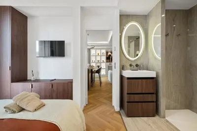 a bedroom with a bed and a sink and a mirror at luxueux, spacieux dans le quartier du port in Nice