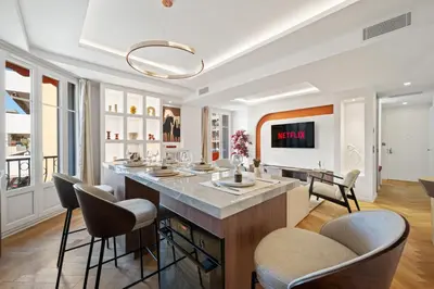 a kitchen with a large island with bar chairs at luxueux, spacieux dans le quartier du port in Nice