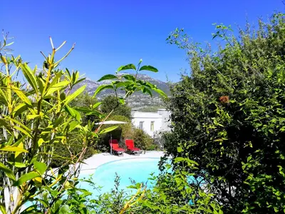 a swimming pool with two red chairs next to a house at Villa Nice Côte d'Azur piscine privée rez de chaussée in La Gaude