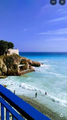 two people surfing on a beach near the ocean at Central & Beach in Nice
