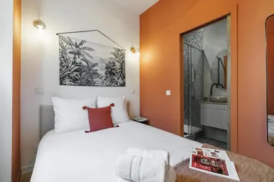 a bedroom with a large white bed and a window at 44 LAMARTINE - Charmant 2 pieces - Centre-ville in Nice