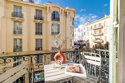 a table with a vase on a balcony with buildings at 44 LAMARTINE - Charmant 2 pieces - Centre-ville in Nice