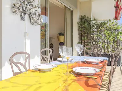 a dining table with a yellow table cloth and glasses at Apartment Le Sirius by Interhome in Nice
